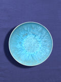 Assiette creuse en céramique émail bleu água Céladon, sur fond coloré