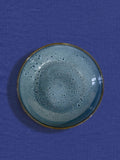 Assiette creuse en céramique émail bleu marin Céladon, sur fond coloré