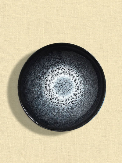 Assiette creuse en céramique émail noir écume Céladon, sur fond coloré