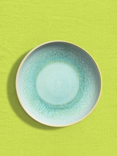 Assiette creuse en céramique émail vert minéral Céladon, sur fond coloré