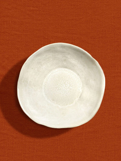 Assiette creuse Onda en céramique émail beige sable Céladon, sur fond coloré
