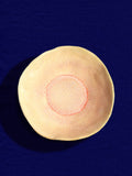 Assiette creuse Onda en céramique émail corail doré Céladon, sur fond coloré