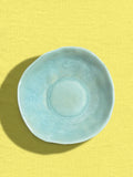 Assiette creuse Onda en céramique émail vert d'eau Céladon, sur fond coloré