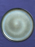 Assiette de présentation en céramique émail bleu brume Céladon, sur fond coloré