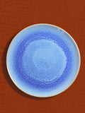 Grande assiette en céramique émail bleu minéral Céladon, sur fond coloré