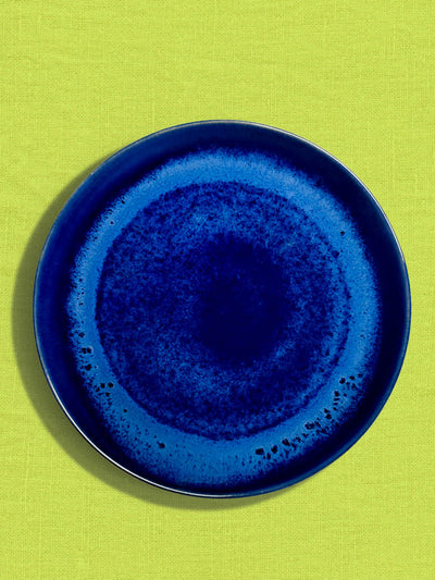 Grande assiette en céramique émail bleu odyssée Céladon, sur fond coloré