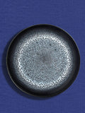 Grande assiette en céramique émail noir écume Céladon, sur fond coloré