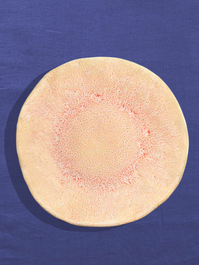 Grande assiette Onda en céramique émail corail doré Céladon, sur fond coloré