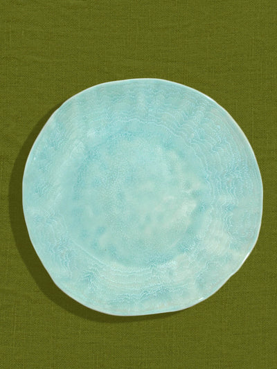 Grande assiette Onda en céramique émail vert d'eau Céladon, sur fond coloré