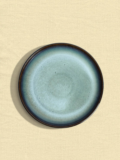 Petite assiette en céramique émail bleu brume Céladon, sur fond coloré