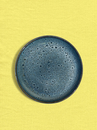 Petite assiette en céramique émail bleu marin Céladon, sur fond coloré
