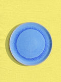 Petite assiette en céramique émail bleu minéral Céladon, sur fond coloré