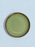 Petite assiette en céramique émail vert rivage Céladon, sur fond coloré