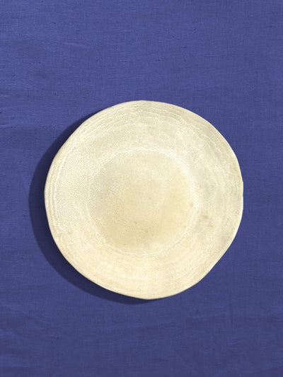 Petite assiette Onda en céramique émail beige sable Céladon, sur fond coloré
