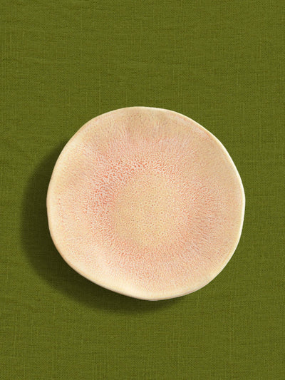 Petite assiette Onda en céramique émail corail doré Céladon, sur fond coloré