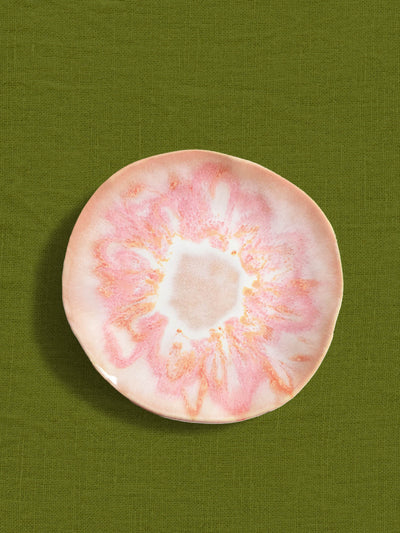 Petite assiette Onda en céramique émail rose anémone Céladon, sur fond coloré