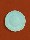 Petite assiette Onda en céramique émail vert d'eau Céladon, sur fond coloré
